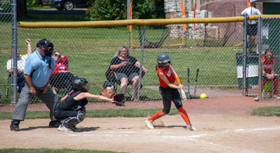 Batter mid-swing about to hit ball.