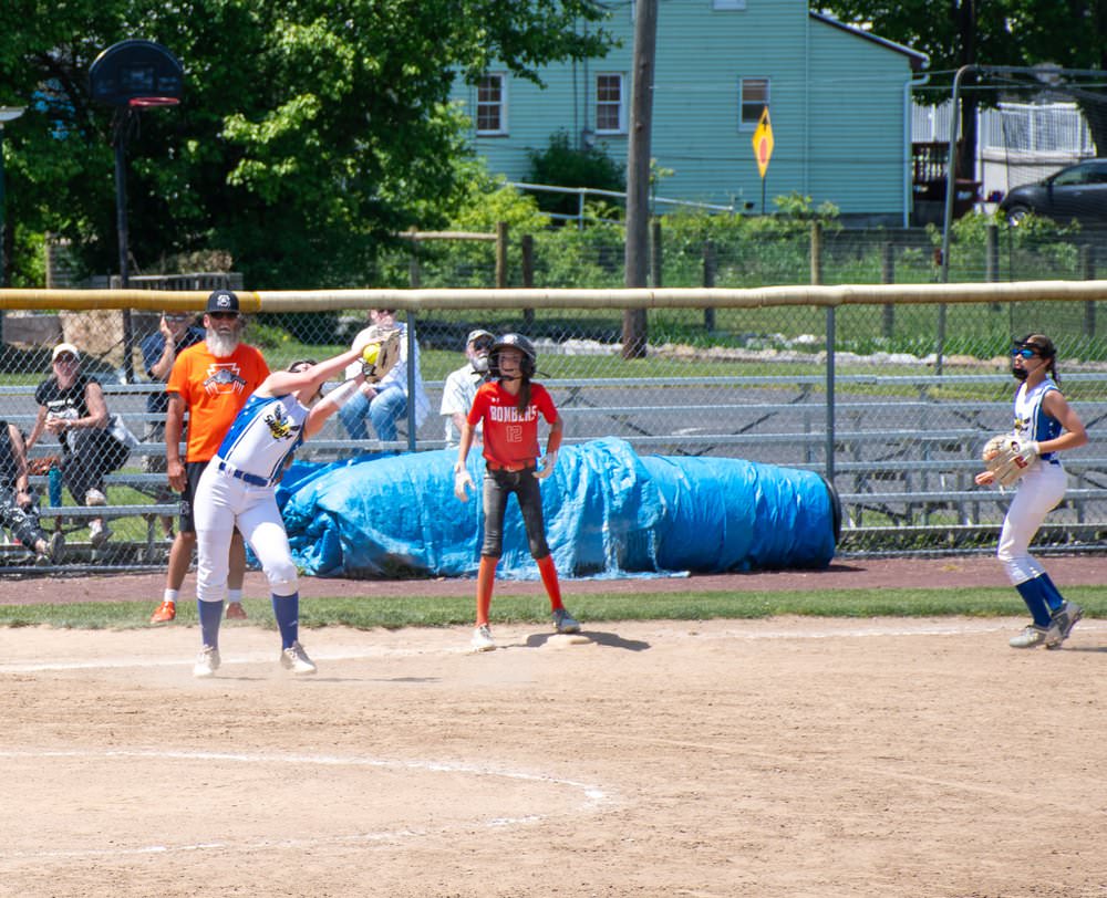 Thirdbaseman catching ball as runner stands on third base.