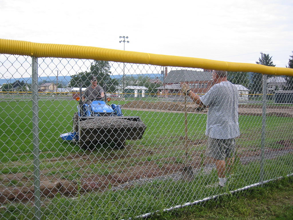 Leon Fultz driving a tractor with a bucket full of gravel when they were renovating the Spring Township ballfield.